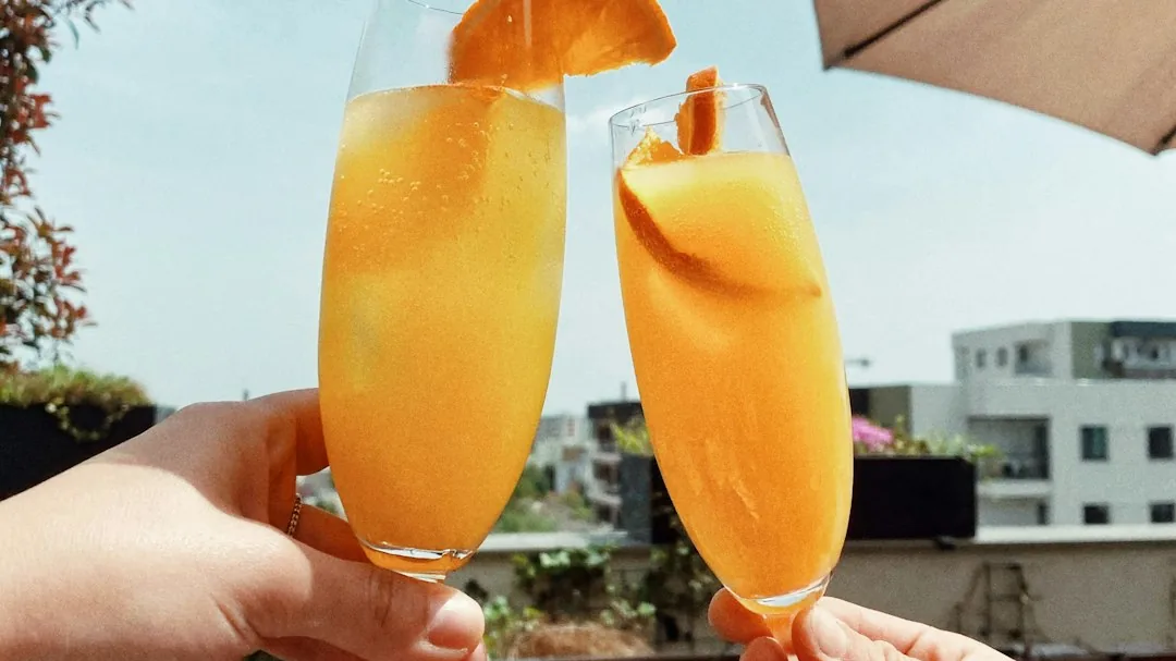 Two people toasting with wine glasses at a brunch table
