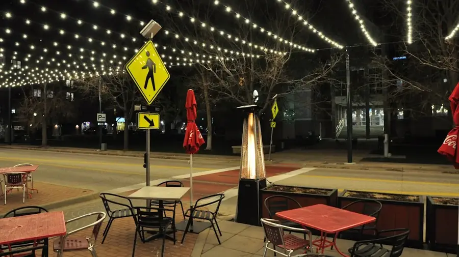 Outdoor pub space at night with string lights and warm lighting